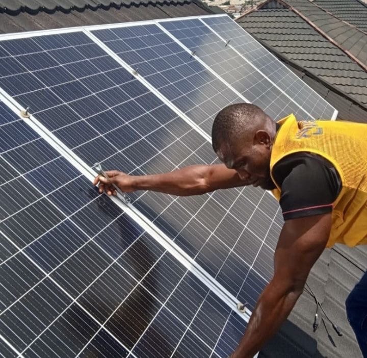 African technician installing rooftop solar panels
