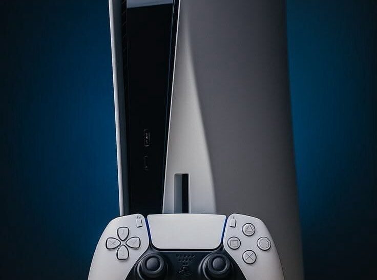 PlayStation 5 console beside physical game discs.