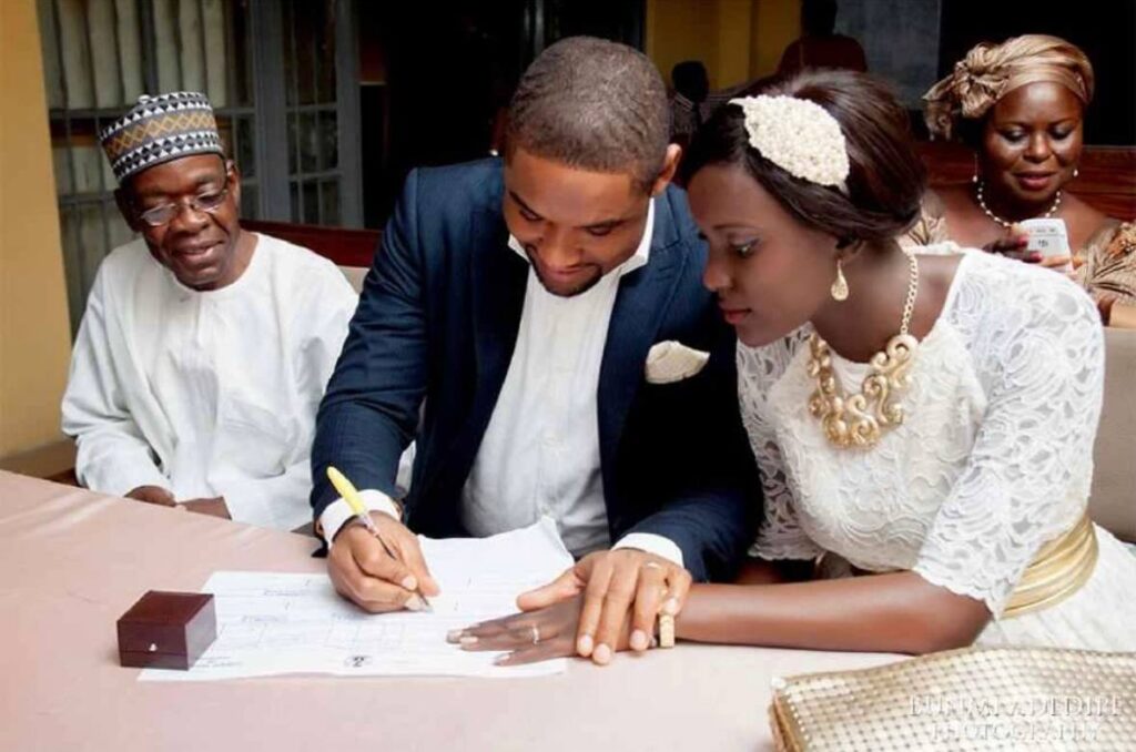 Couple signing a marriage certificate in Ghana